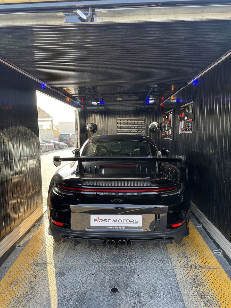 Porsche 911 GT3 secured inside the enclosed transporter for BRITFIX vehicle recovery