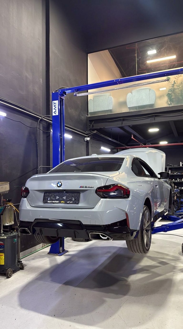 BMW M240i raised on a two-post lift for servicing at BRITFIX