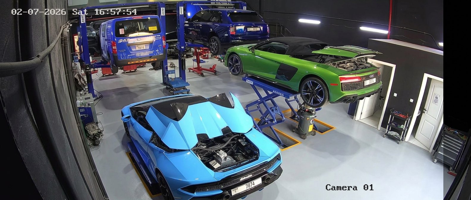 Blue Lamborghini Huracan Spyder and green Audi R8 Spyder on lifts at BRITFIX Al Quoz