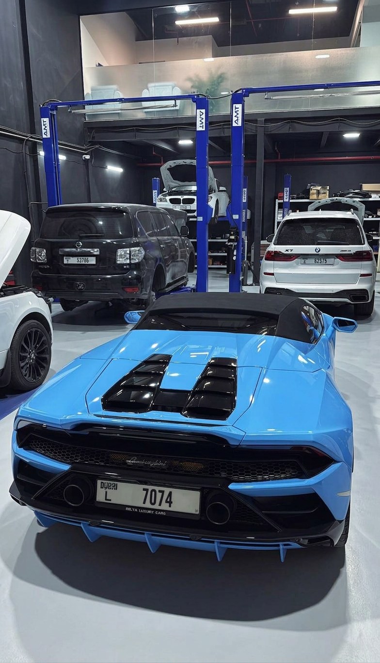 Lamborghini Huracan EVO Spyder in the BRITFIX workshop alongside a BMW X7 and Nissan Patrol