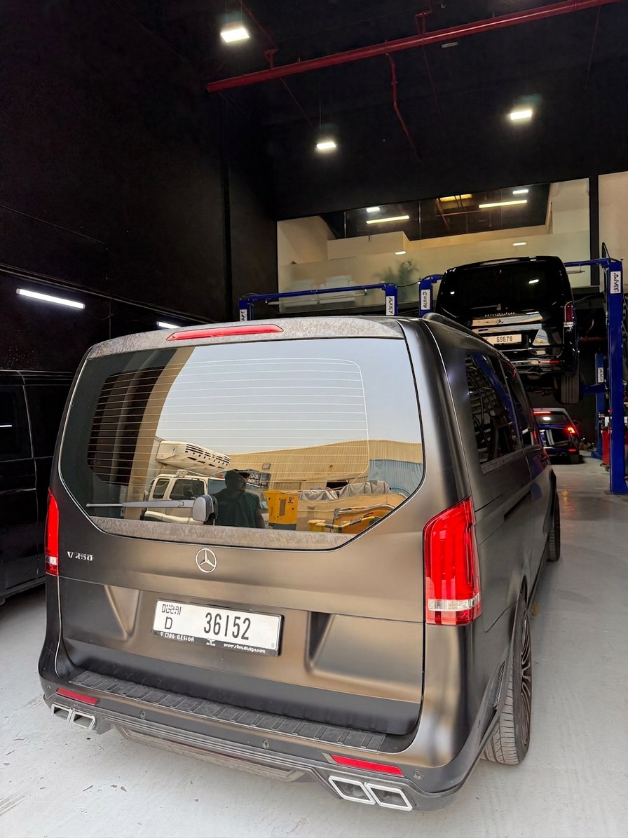 Custom-wrapped Mercedes-Benz V250 in the BRITFIX workshop with a V-Class on the lift behind