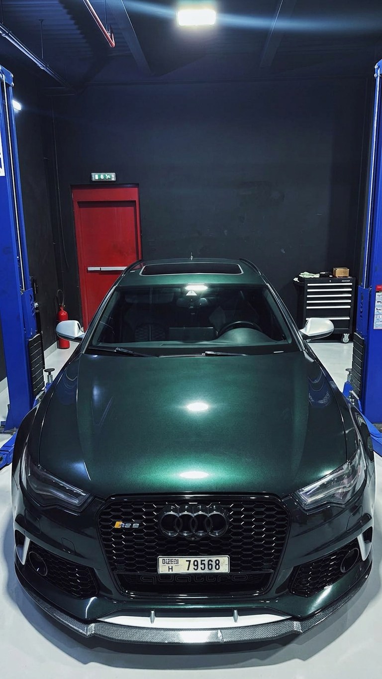 Green Audi RS6 Avant between the two-post lifts at the BRITFIX Al Quoz workshop